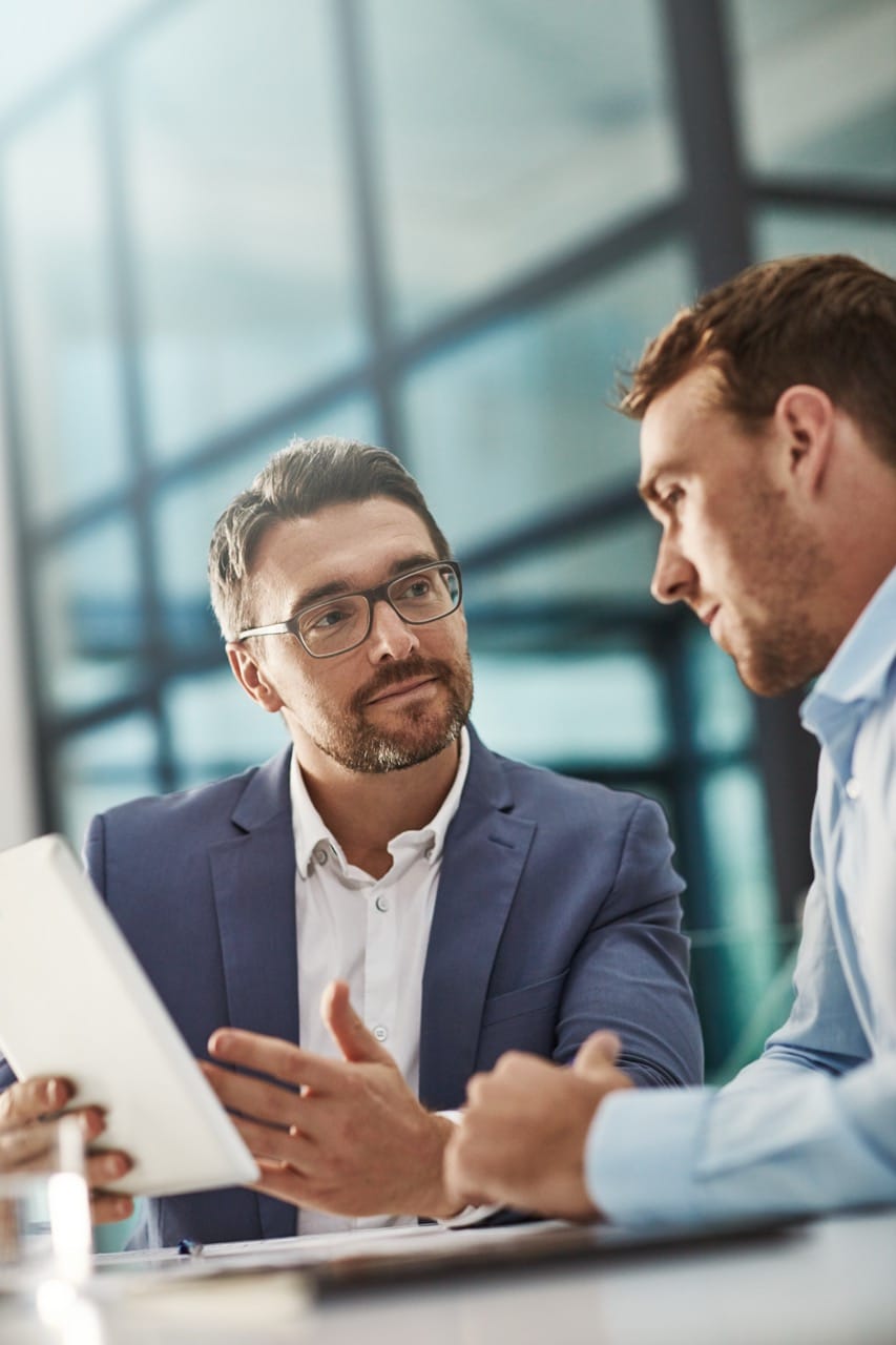 Coaching, Training And Business People With Tablet In Office Workplace. Collaboration, Mentor And Men Or Employees With Technology Planning Sales, Marketing Or Advertising Strategy In Company Meeting - Advanced Intralogistics