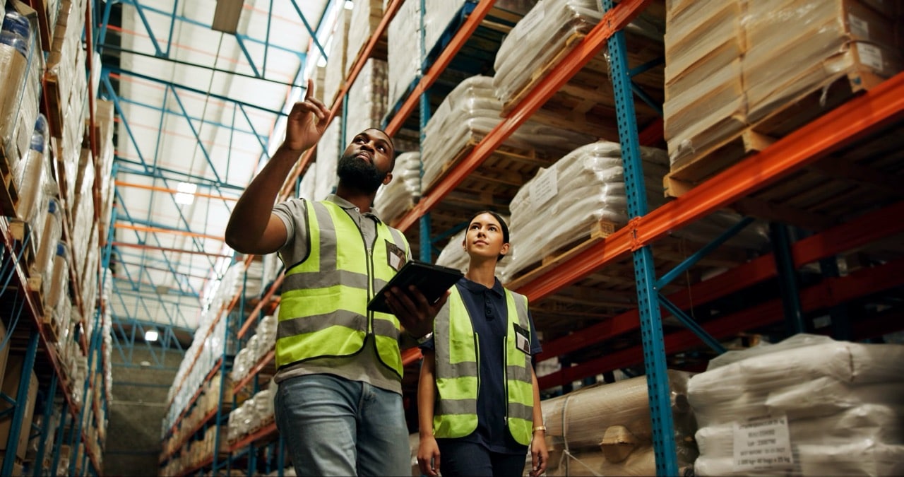 Woman, Man And Logistics In Warehouse With Tablet For Quality Control, Stock Management Or Delivery. People, Factory And Worker With Technology, Cargo And Freight For Supply Chain Or Shipping Company - Advanced Intralogistics
